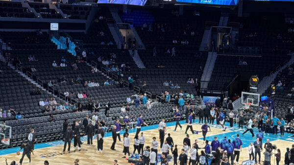 View of basketball court, players and fans at Spectrum Center in Charlotte.