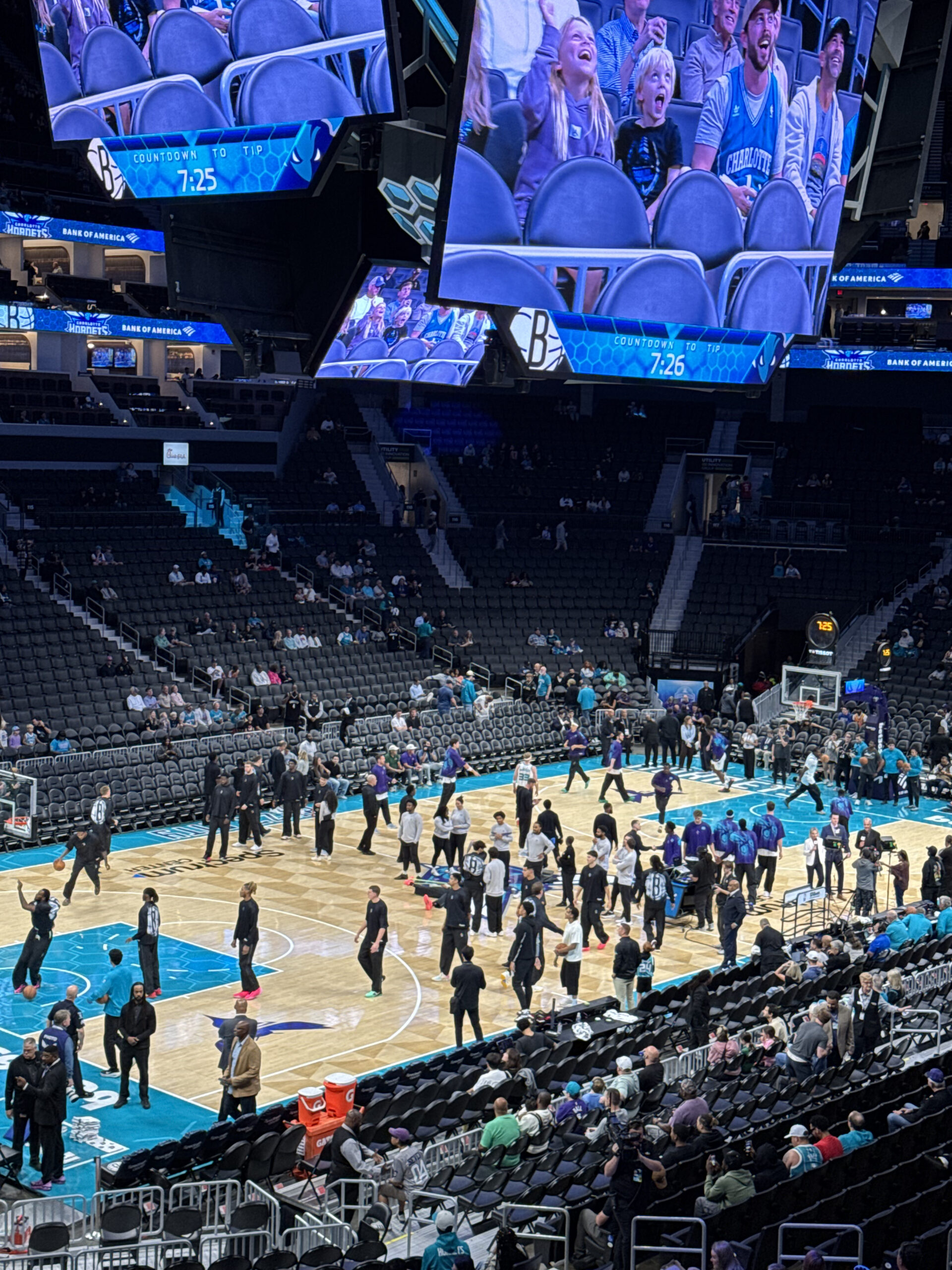 View of basketball court, players and fans at Spectrum Center in Charlotte.